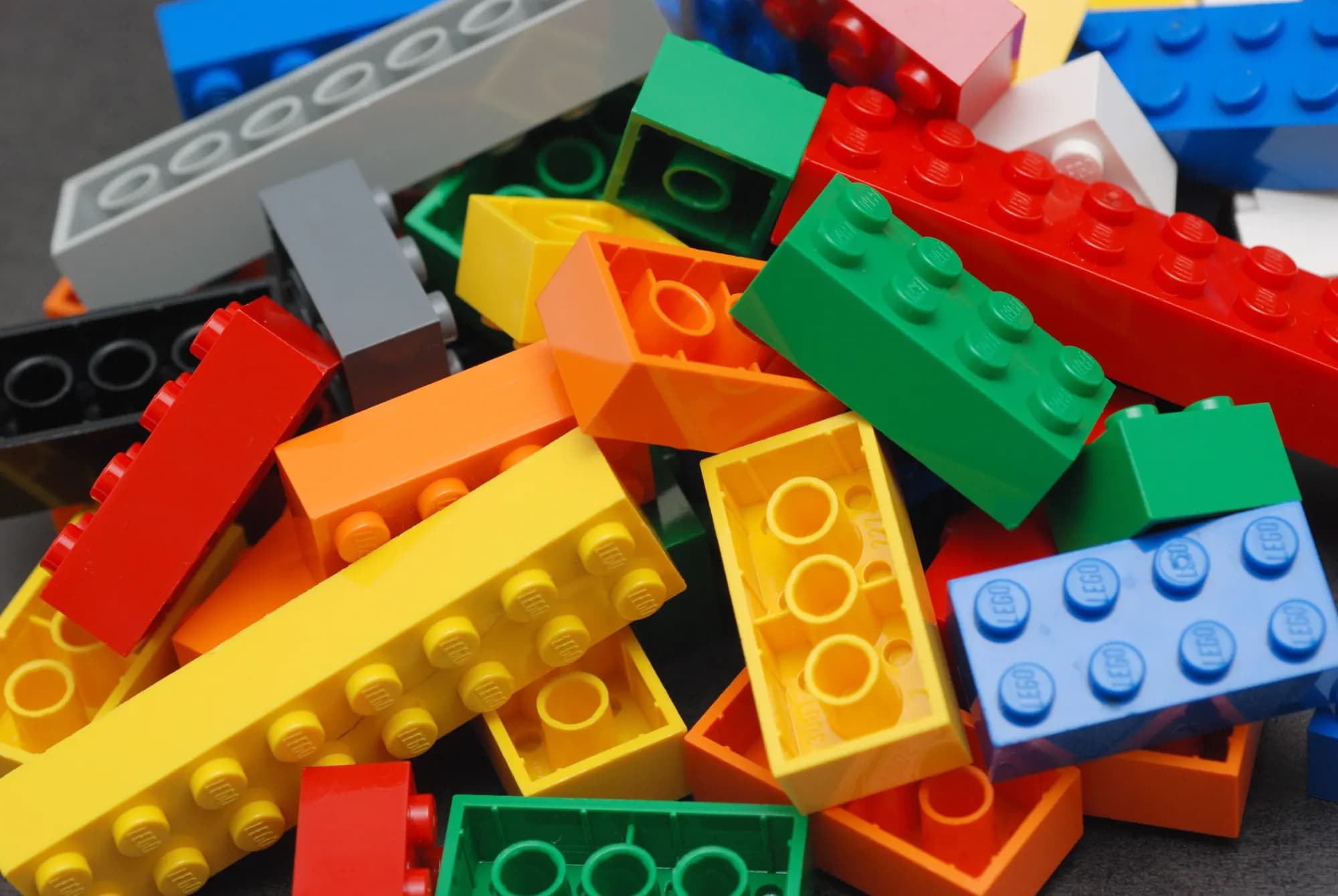 A close-up pile of LEGO bricks in many colours and sizes.